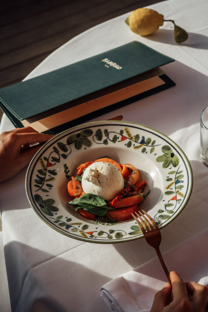 Entrée du Bambino Ibiza : burrata et salade tomate et poivron rouge,  sur table 