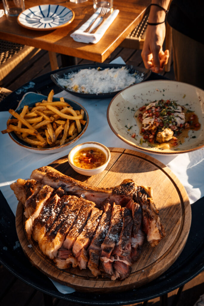 Photo de la cote de bœuf Angus, de ses frites maison et de l’aubergine à la flamme. Ce sont des plats servis au Monkey Ibiza